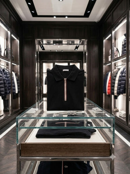 Folded black Moncler half zip polo t-shirt on display table
