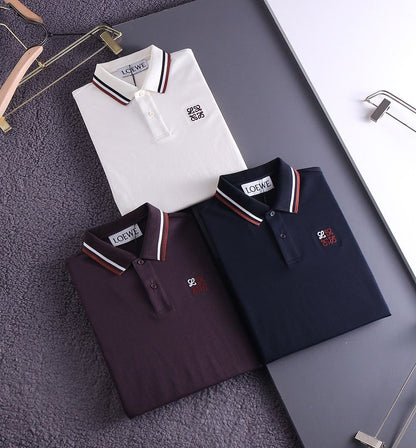 Three premium polo shirts in white, plum and navy folded together, striped collar detail
