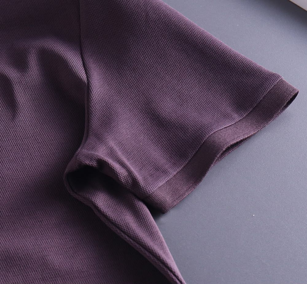 Close-up of plum polo shirt sleeve and fabric texture
