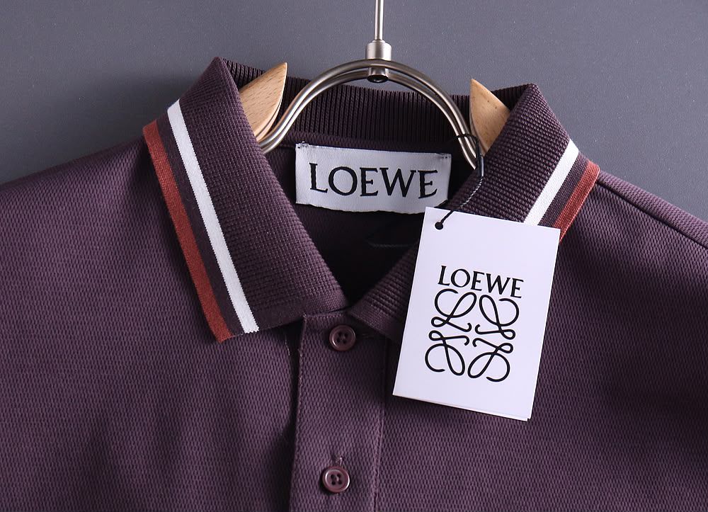 Close-up of plum polo shirt collar with striped detail and brand tag on hanger
