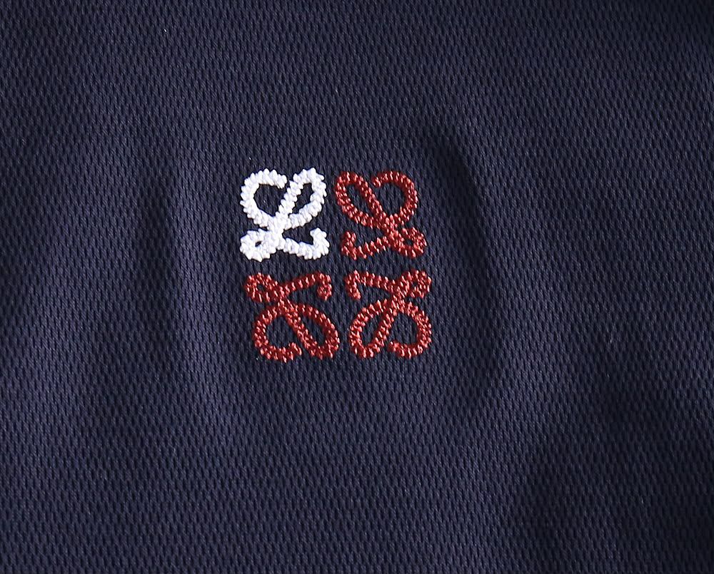 Close-up of embroidered logo detail on navy polo shirt fabric

